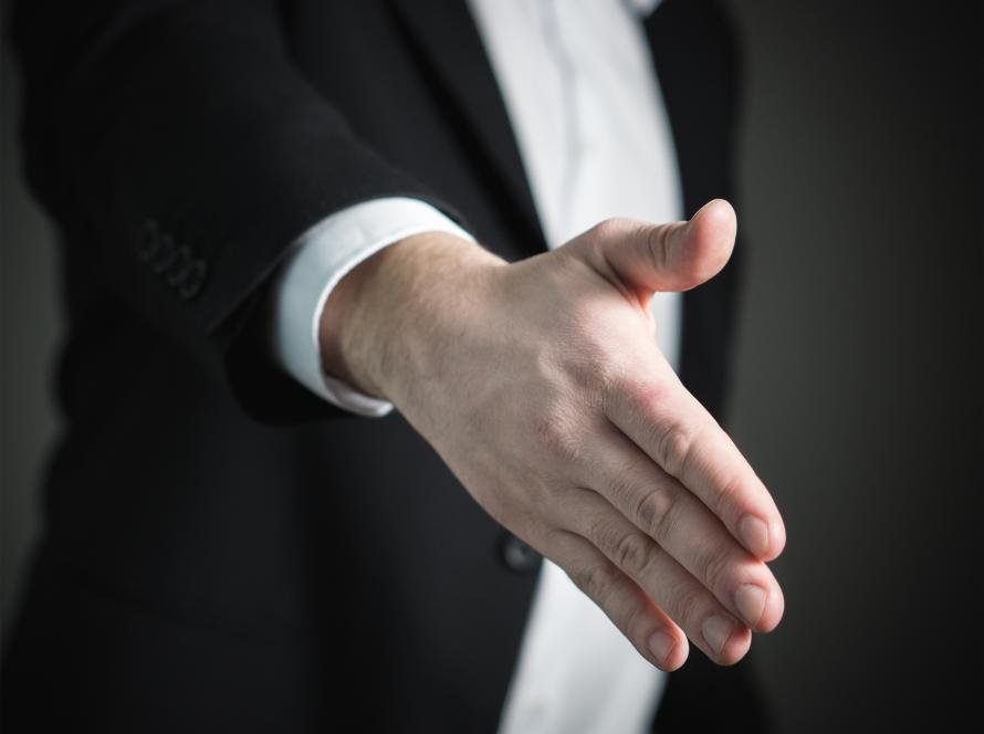 A close-up handshake representing communication, repair and apology.