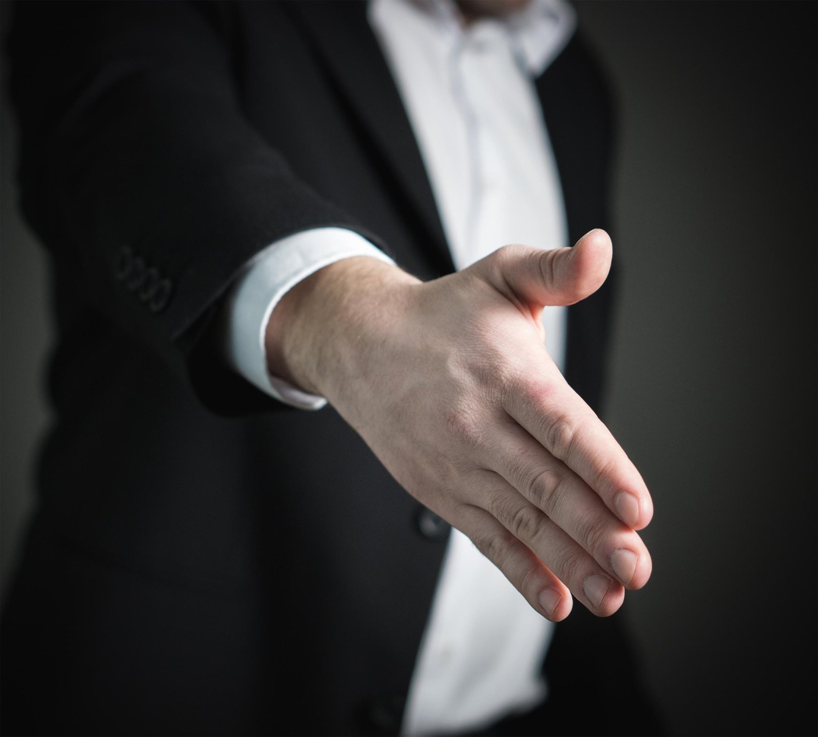 A close-up handshake representing communication, repair and apology.